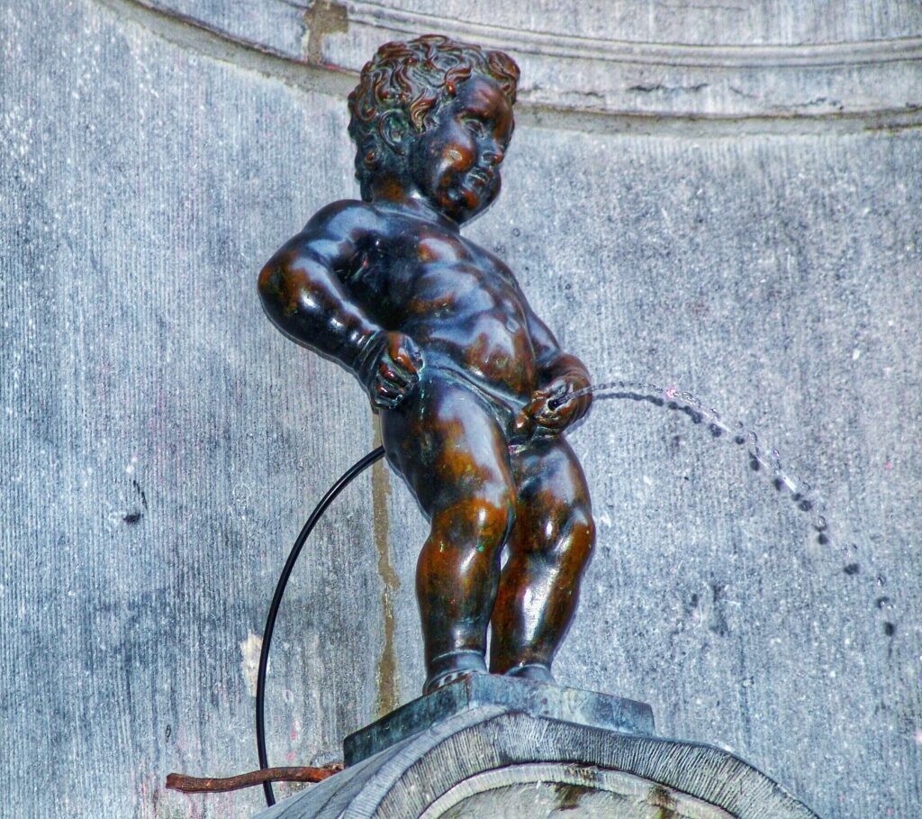 low-angle-view-bronze-manneken-pis-sculpture-fountain-against-wall
